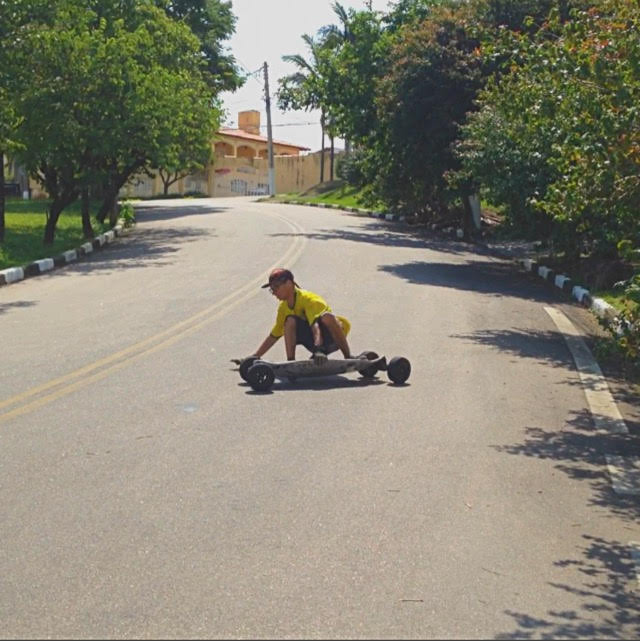 Rayan praticando carveboard em uma ladeira, mostrando versatilidade em esportes de prancha.