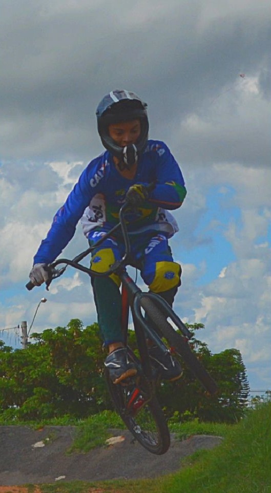 Rayan realizando um salto de bicicleta BMX, destacando sua habilidade e paixão pelo esporte.