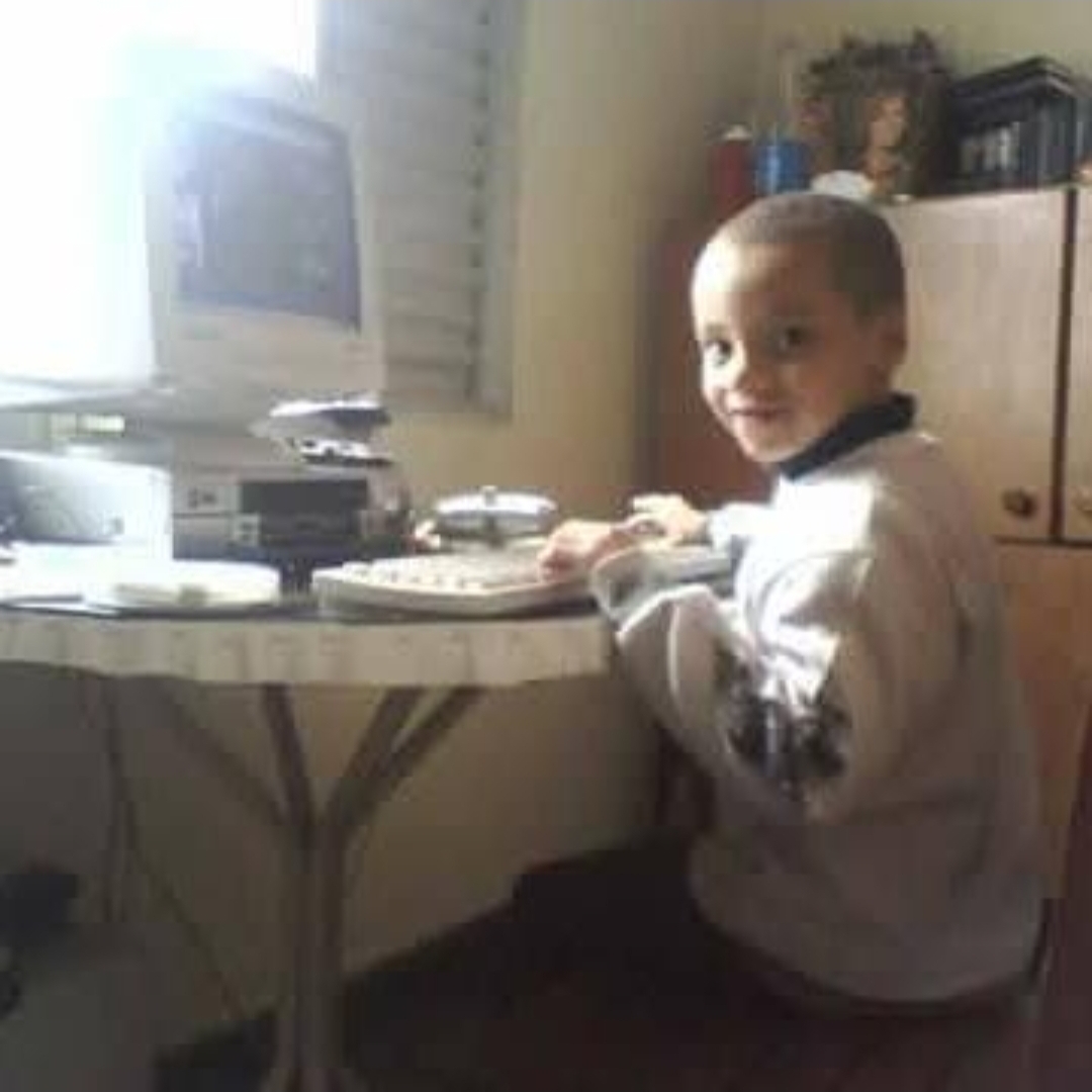 foto do Rayan quando criança utilizando um computador 