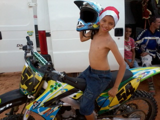 Rayan criança em uma motocicleta de motocross, simbolizando aventura e superação.