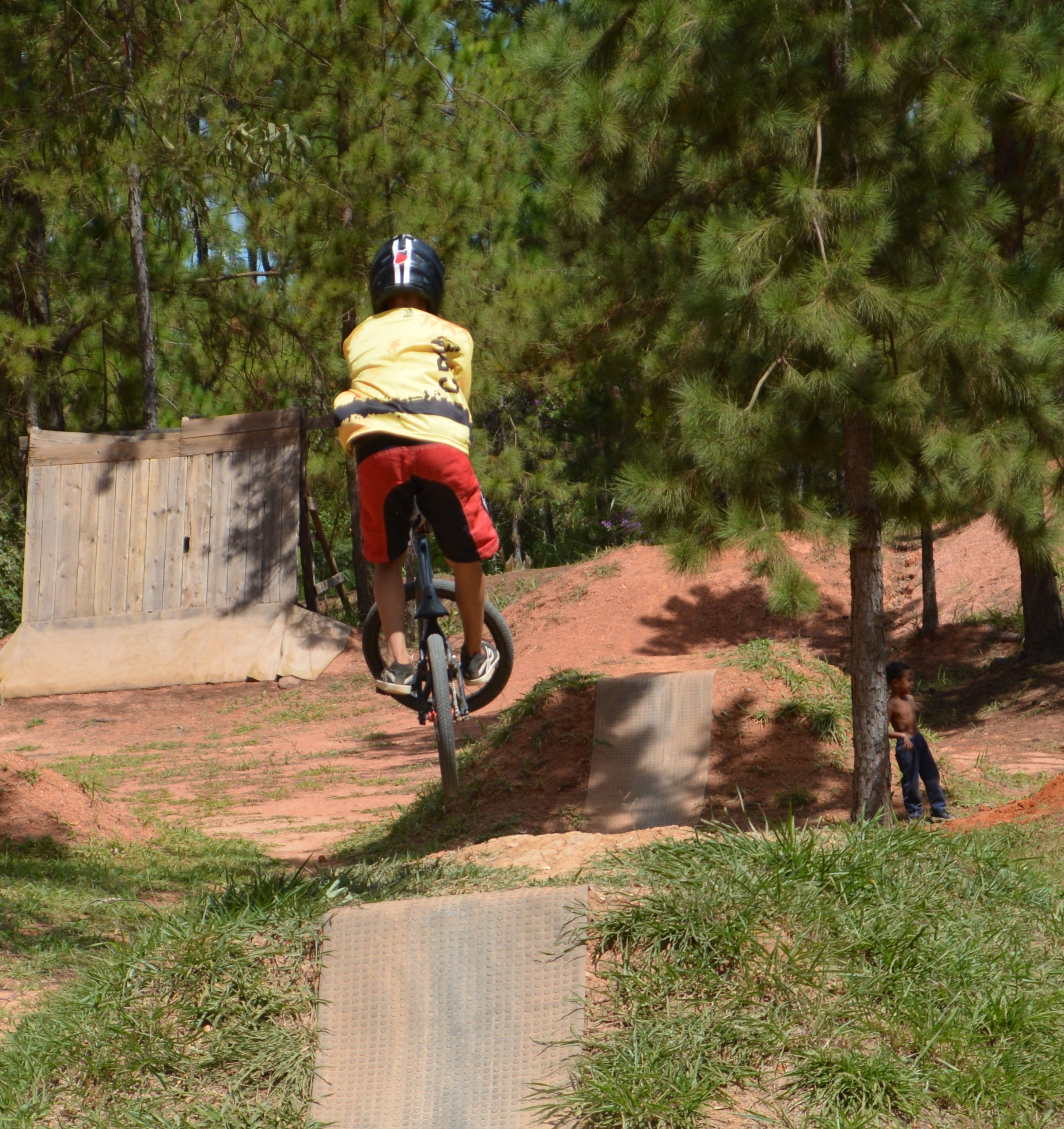 Rayan em pleno voo com sua bicicleta, capturando a emoção e liberdade do BMX.